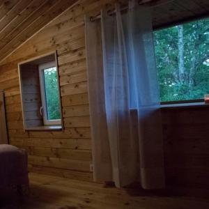 a bedroom with a window in a log cabin at Gîte avec spa privatif et piscine de 2 à 10 voyageurs in Brassac