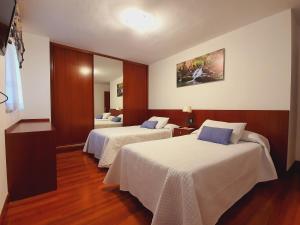 a hotel room with two beds and a mirror at Casa Rural ASTEI in Muxika