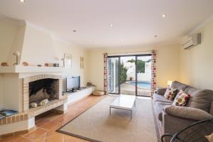 a living room with a couch and a fireplace at Seagull House in Quinta do Lago