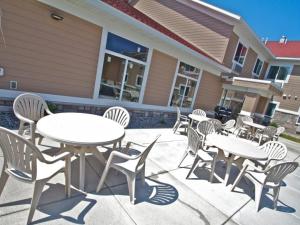 un grupo de mesas y sillas frente a una casa en Grandstay Hotel and Suites Parkers Prairie, en Parkers Prairie