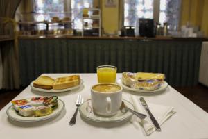 una mesa con dos platos de comida y una taza de café en Hotel Reyes Catolicos, en Salamanca