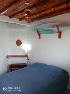 1 dormitorio con cama azul y techo de madera en Hostal Puerto Engabao Surf Shelter, en Engabao