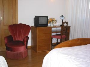 a bedroom with a television and a bed at Hotel Santos in Guarda