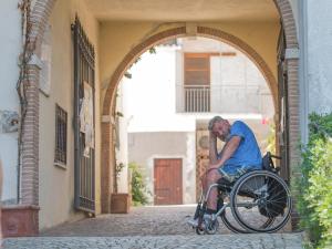 een man in een rolstoel zittend in een boog bij Centro Ferie Salvatore in San Felice Circeo