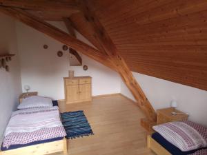 - une chambre mansardée avec 2 lits et des plafonds en bois dans l'établissement Ferienwohnung Linke "Grünblick", à Grimma