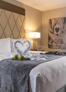 a hotel room with a bed with two heart shaped towels at Palazzo Lakeside Hotel in Kissimmee