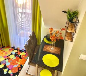 a dining room table with two chairs and a table with yellow plates at Apartament Limonka in Wierzchucino +6 photos