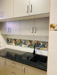 a kitchen with white cabinets and a sink at Apartament Limonka in Wierzchucino