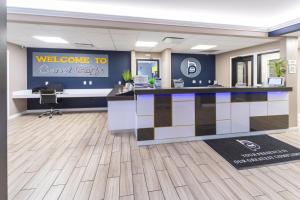 una hall con reception e un cartello di benvenuto per i circuiti coralli di BridgePointe Inn & Suites by BPhotels, Council Bluffs, Omaha Area a Council Bluffs