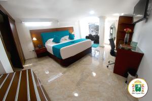 弗洛伦西亚Hotel Caquetá Real HSC的一间带大床的卧室和一间客厅