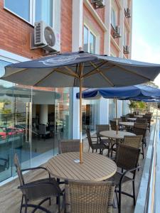 a table and chairs with an umbrella on a patio at Hotel Himmelblau in Blumenau