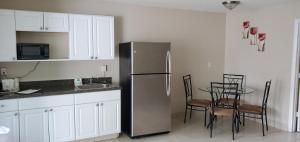 uma cozinha com um frigorífico e uma mesa com cadeiras em Clearwater Beach Hotel em Clearwater Beach
