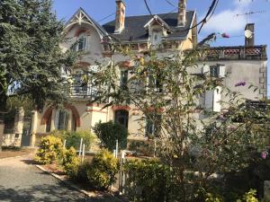 une grande maison blanche avec un jardin en face de celle-ci dans l'établissement Le Logis de la Venise Verte, à Saint-Hilaire-la-Palud