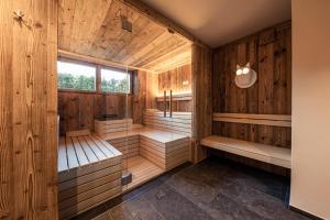 an empty sauna with wooden walls and benches at B&B Boutiquehotel Clara in Brunico