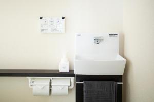 W łazience znajduje się umywalka i dozownik ręczników. w obiekcie YUFU-INN - MATSU SUITE - Vacation STAY 95157 w mieście Yufu