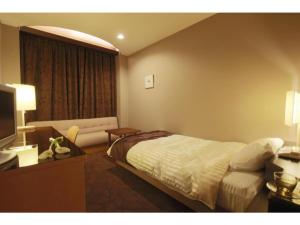 ein Hotelzimmer mit einem Bett und einem Sofa in der Unterkunft Hotel Grand Vert Gizan - Vacation STAY 95360 in Gifu
