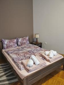 a bed with two pillows on it in a bedroom at Kata's Place in Subotica