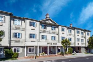 een groot wit gebouw op de hoek van een straat bij Hotel 1550 - SFO Airport West in San Bruno