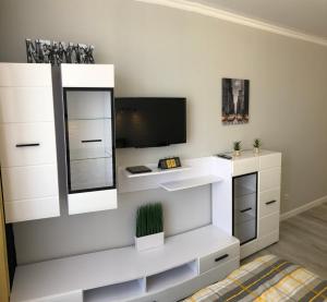 ein weißes Ankleidezimmer mit einem Spiegel und einem TV in der Unterkunft Apartment Studio New York 45 in Irpin