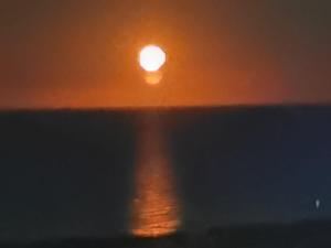 einen Sonnenuntergang über dem Meer mit der Sonne in der Ferne in der Unterkunft B&B La Casa di Era in Porto San Giorgio
