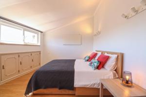 Un dormitorio con una cama con almohadas rojas y una mesa. en Central Apartment - Viana City Centre en Viana do Castelo