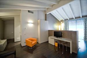 a living room with a desk and a television at Piccolo Hotel in Malcesine