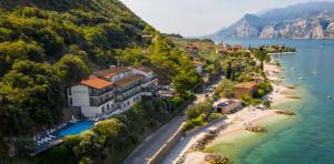 eine Luftansicht eines Resorts auf einem Hügel neben dem Wasser in der Unterkunft Piccolo Hotel in Malcesine