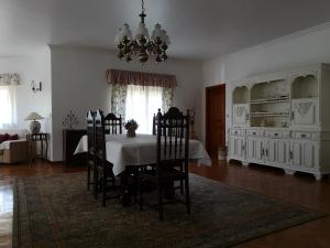 a dining room with a table and chairs and a chandelier at Casal do Morgado, country house to relax in Formigais