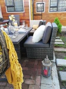 eine Terrasse mit einem Tisch und Korbstühlen sowie einem Tisch und einem Tisch in der Unterkunft Richmond Hill Guest House in Port Elizabeth