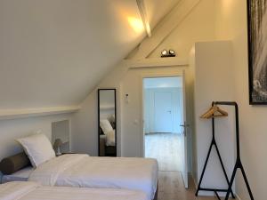 a attic bedroom with two beds and a mirror at Villa Zuid in De Haan