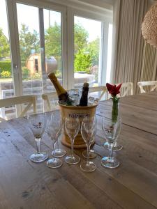 a basket of wine bottles and wine glasses on a table at Villa Zuid in De Haan