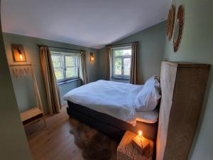 een slaapkamer met een bed met een kaars erin bij Cottage in Ardennes - La Maison aux Moineaux - Fays-Famenne in Sohier