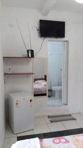 a room with a refrigerator and a bathroom with a toilet at Ao Mare in São Francisco