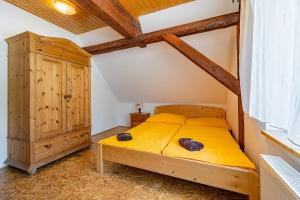 1 dormitorio con cama amarilla y armario de madera en Apartments V Zátiší, en Dolní Morava