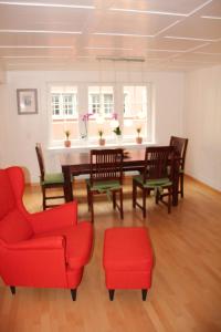 a dining room with red chairs and a table at Rhii B&B in Eglisau