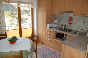 eine Küche mit einem Tisch, einer Spüle und einem Herd in der Unterkunft Landhaus St. Rupert in Bad Hofgastein