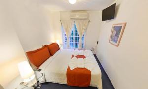 1 dormitorio con 1 cama con edredón naranja y blanco en Hotel Casablanca en Mina Clavero