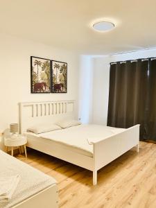 um quarto com uma cama branca e uma cortina preta em TM Aparts em Dortmund