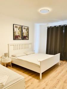 a bedroom with a white bed and a black curtain at TM Aparts in Dortmund