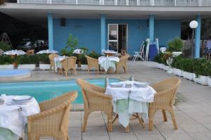 un ristorante con tavoli e sedie accanto a una piscina di Hotel Internazionale a San Mauro a Mare