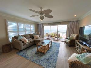 a living room with a couch and a flat screen tv at Sea Oats by Liberte Management in St Pete Beach