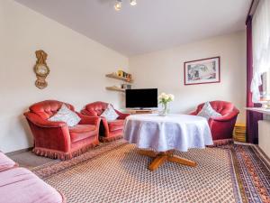 - un salon avec des chaises rouges et une table dans l'établissement Apartment with terrace in Sauerland region, à Medebach