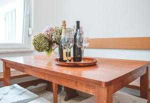 una mesa de madera con copas de vino y flores. en Entoli Apartment, en Podnanos
