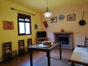 sala de estar con mesa y chimenea en Alojamiento Rural Alfaguara, en Tolox