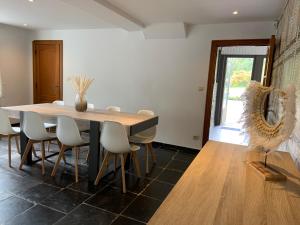 a dining room with a wooden table and chairs at Ancienne maison rénovée au calme in Wanze