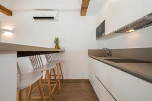 a kitchen with white walls and a counter and stools at Camelina Suites in San Antonio Bay