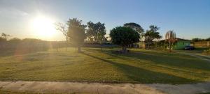 a grassy field with the sun in the background at Pousada Chácara Sonho in Hortolândia