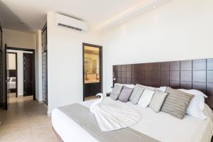 1 dormitorio con 1 cama blanca grande con almohadas blancas en Vivo Resorts, en Puerto Escondido