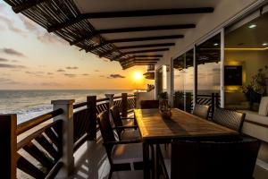 a wooden table and chairs on a balcony with the ocean at Vivo Resorts in Puerto Escondido