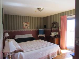 een slaapkamer met een groot bed en een raam bij Shepody Bay Inn in Hopewell Cape